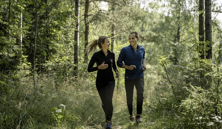Ungt par løper i skogen